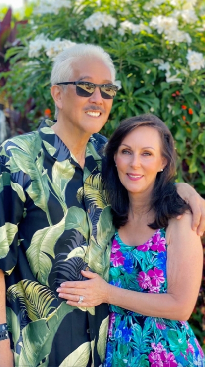 Dr Yamahata and his wife smiling wearing vacation attire